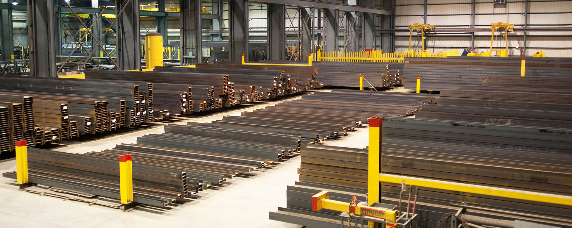 Steel plate stock in a warehouse with overhead cranes